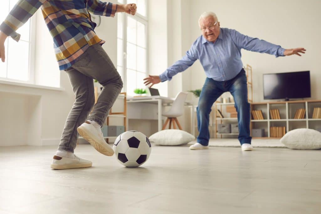 Grandpa playing soccer with grandchild - aging parents