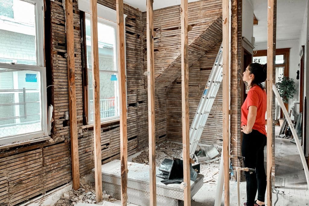 woman standing in a room that's being remodeled looking at the wall