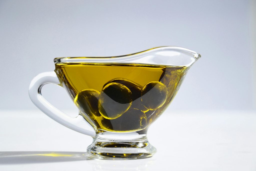 Bowl of olive oil with olives in it