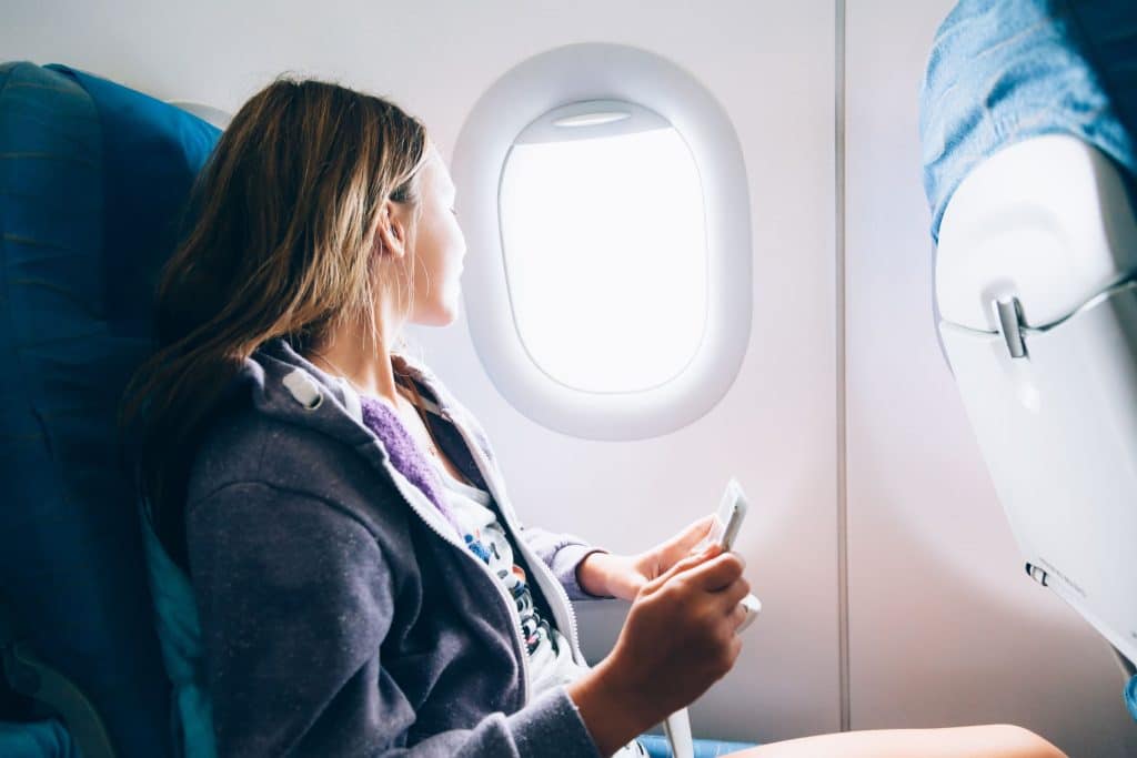 A woman looking out of the window of an airplane.